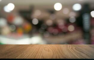 vuoto di legno tavolo nel davanti di astratto sfocato sfondo di caffè negozio . può essere Usato per Schermo o montaggio il tuo prodotti.mock su per Schermo di Prodotto foto