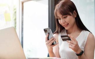 ritratto di una donna felice che acquista online con uno smartphone in ufficio.