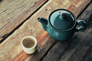 caldo Tè, tè tazza con pentola su legna tavolo foto