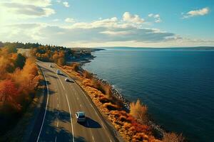 aereo Visualizza di un' grande autostrada senza pedaggio con macchine su il riva di un' lago nel autunno foto