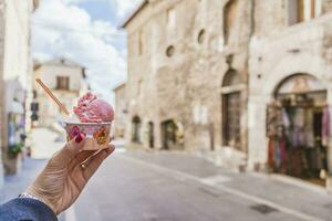 Italia, umbria, assisi, donna di mano Tenere un' tradizionale italiano gelato nel il cittadina centro foto