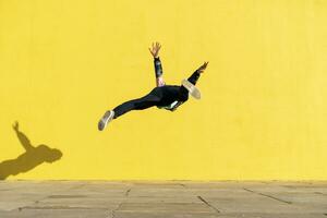 acrobata salto capriole nel davanti di giallo parete foto