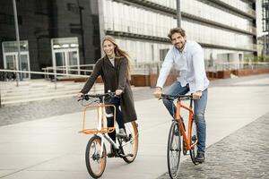 sorridente coppia equitazione bicicletta nel il città foto