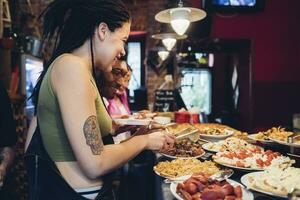 contento amici assunzione cibo a partire dal buffet nel un' ristorante foto