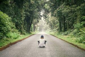 nuovo zelanda, Sud isola, jackson baia, haast jackson baia strada, giovane uomo seduta su strada foto