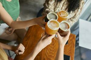 femmina amici tintinnante mestiere birra bicchieri nel un' pub foto