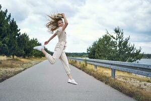 allegro donna salto su rurale strada foto