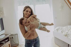 madre giocando con sua bambino figlio a casa foto