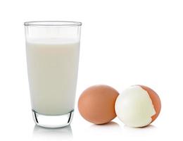 bicchiere di latte e uova isolati su sfondo bianco foto