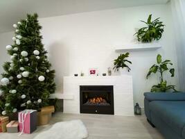 un' vivente camera a periodo natalizio illuminato solo di il fuoco e Natale albero. foto