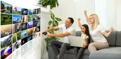 giovane famiglia avendo divertimento giocando videogiochi su un' enorme schermo a casa foto