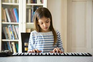 ragazza giocando rotolo pianoforte a casa foto