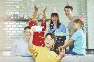 madre e figli maschi festeggiare della nonna bithday nel loro cucina, ragazzo assunzione selfie foto