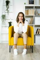 sorridente donna d'affari seduta con testa nel mani su divano a ufficio foto