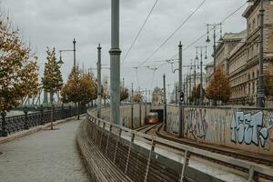 famoso giallo tram andando su di il tunnel nel budapest durante il nuvoloso autunno mattina con libertà ponte nel il sfondo foto