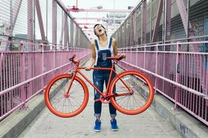 Stati Uniti d'America, nuovo York città, Williamsburg, donna con rosso da corsa ciclo su williamsburg ponte foto
