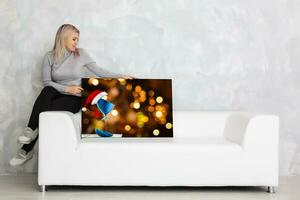 giovane ragazza detiene foto tela a casa su il divano