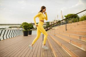 giovane donna che corre sulle scale in riva al fiume foto