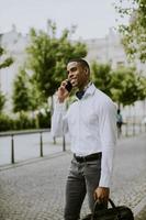 giovane uomo d'affari afroamericano che utilizza un telefono cellulare