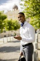 giovane uomo d'affari afroamericano che utilizza un telefono cellulare foto