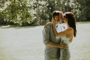 giovane coppia affettuosa che si diverte sull'erba verde foto