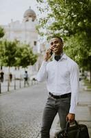 giovane uomo d'affari afroamericano che utilizza un telefono cellulare