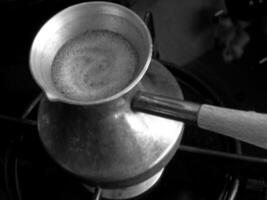 barista che prepara una bevanda calda e gustosa dal turco di rame foto