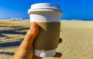 caffè per partire boccale su il spiaggia sabbia mare onde. foto