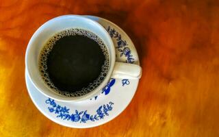 blu bianca tazza pentola con nero caffè di legno tavolo Messico. foto