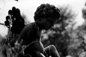 bellissimo Cupido angelo statua con Ali su indietro nel Vintage ▾ giardino foto