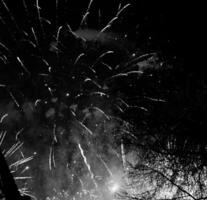 scoppiano fuochi d'artificio colorati nel cielo notturno scuro foto