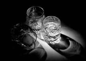 vuoto tiro bicchieri per alcolizzato bevande Vodka in piedi su di legno tavolo foto