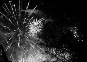 scoppiano fuochi d'artificio colorati nel cielo notturno scuro foto