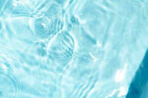 trasparente blu chiaro acqua superficie struttura con increspature astratto di superficie blu spruzzo e bolle acqua onde riflessa con luce del sole foto