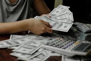 uomini d'affari donne che contano soldi su una pila di 100 dollari americani banconote un sacco di soldi