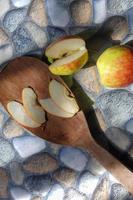 foto di mele in vari stili, alcune sono ancora intatte, altre sono tagliate con uno sfondo di pietra
