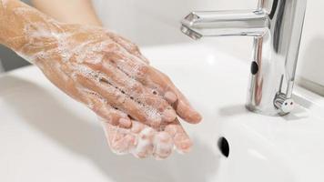 persona che si lava le mani con il sapone foto
