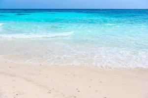 onde del mare limpido e spiaggia di sabbia bianca in estate.