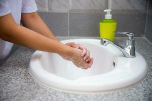 donna lavare mano con sapone foto
