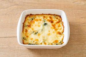 lasagne di spinaci al forno con formaggio in piatto bianco foto