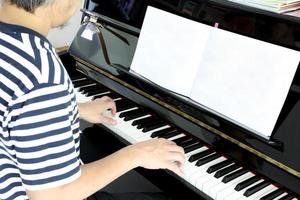 uomo asiatico che suona il pianoforte foto