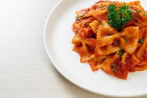 Farfalle in salsa di pomodoro con prezzemolo - Italian food style foto