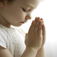 Childs mani nel preghiera posizione su bianca sfondo foto