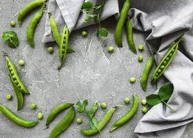 baccelli di piselli verdi su uno sfondo di cemento. cibo organico. foto