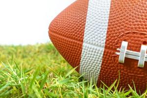 pallone da football americano su erba verde isolato su sfondo bianco foto