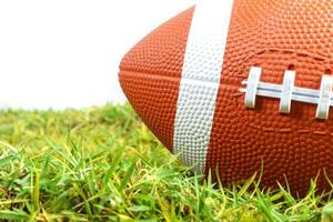 pallone da football americano su erba verde isolato su sfondo bianco foto
