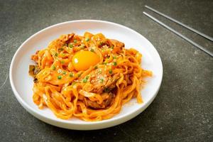 noodles udon saltati in padella con kimchi e maiale - stile alimentare coreano foto