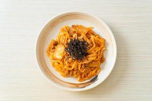 noodles udon saltati in padella con kimchi e maiale - stile alimentare coreano foto