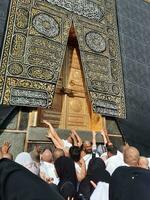 Mecca, Arabia arabia, ago 2023 - pellegrini a partire dal tutti al di sopra di il mondo raccogliere vicino il porta di il kaaba nel Masjid al haram. foto