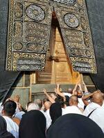 Mecca, Arabia arabia, ago 2023 - pellegrini a partire dal tutti al di sopra di il mondo raccogliere vicino il porta di il kaaba nel Masjid al haram. foto